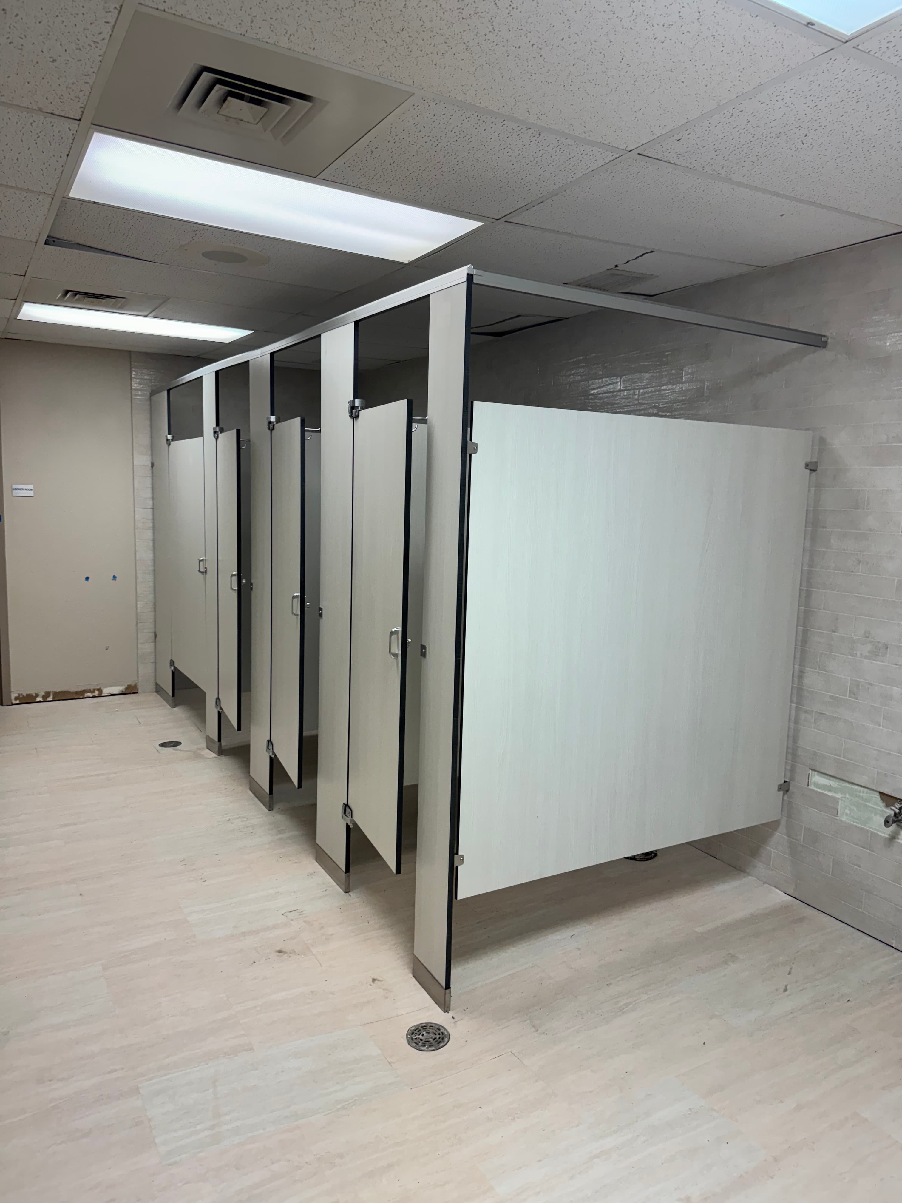 Particiones de fenólico instaladas en un baño comercial