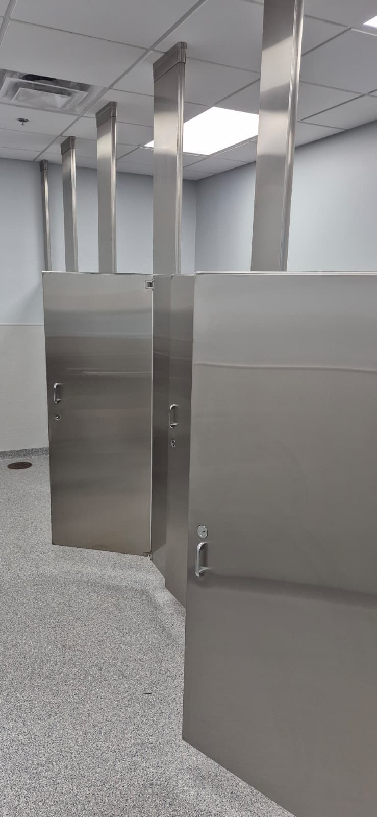 Particiones de acero inoxidable instaladas en un baño comercial